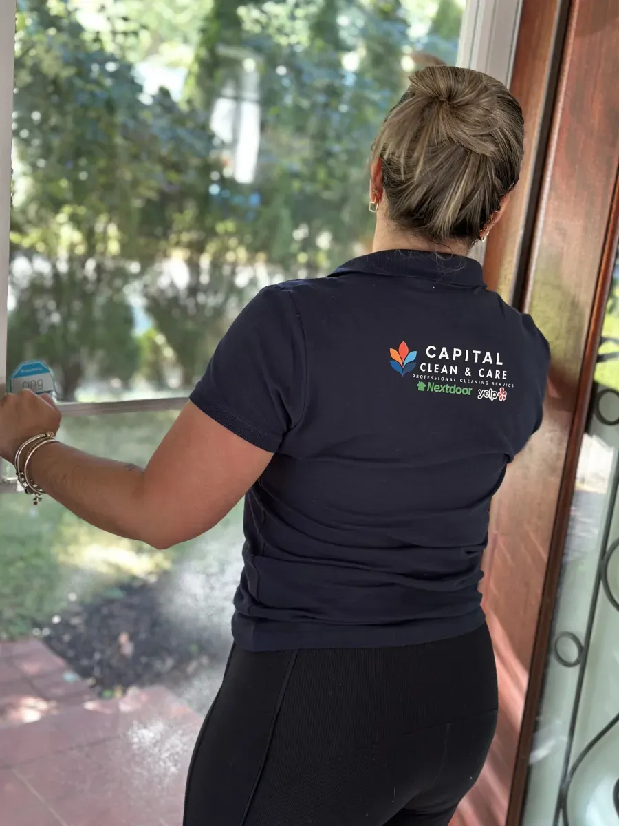 Capital Clean Care professional cleaning a window